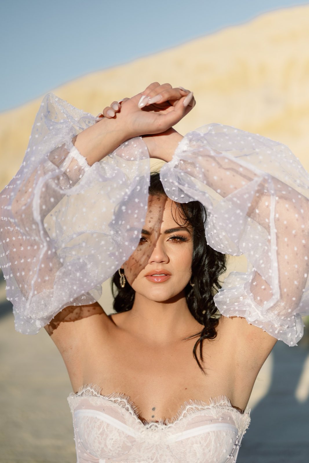 Bride framed by soft sleeves in warm light