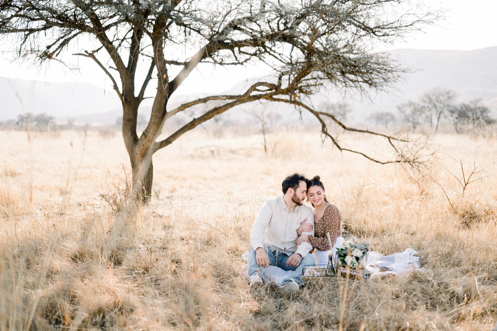 A couple sitting together in a sunlit field