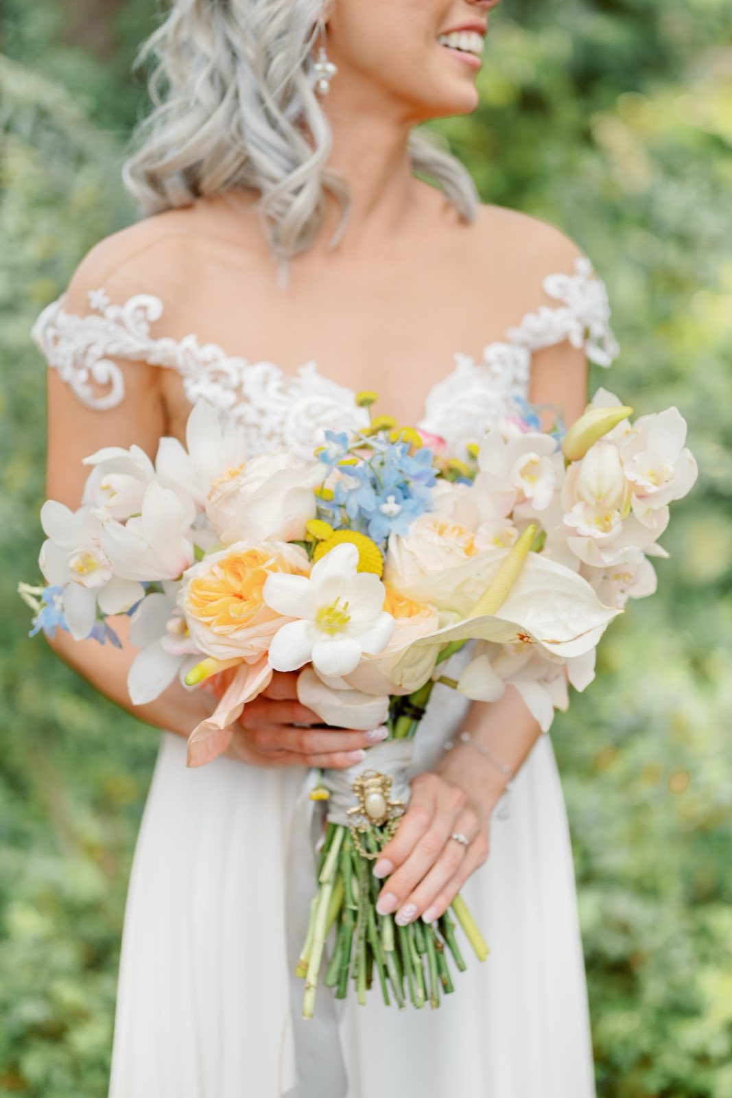 Bride holding a colorful bouquet in a garden