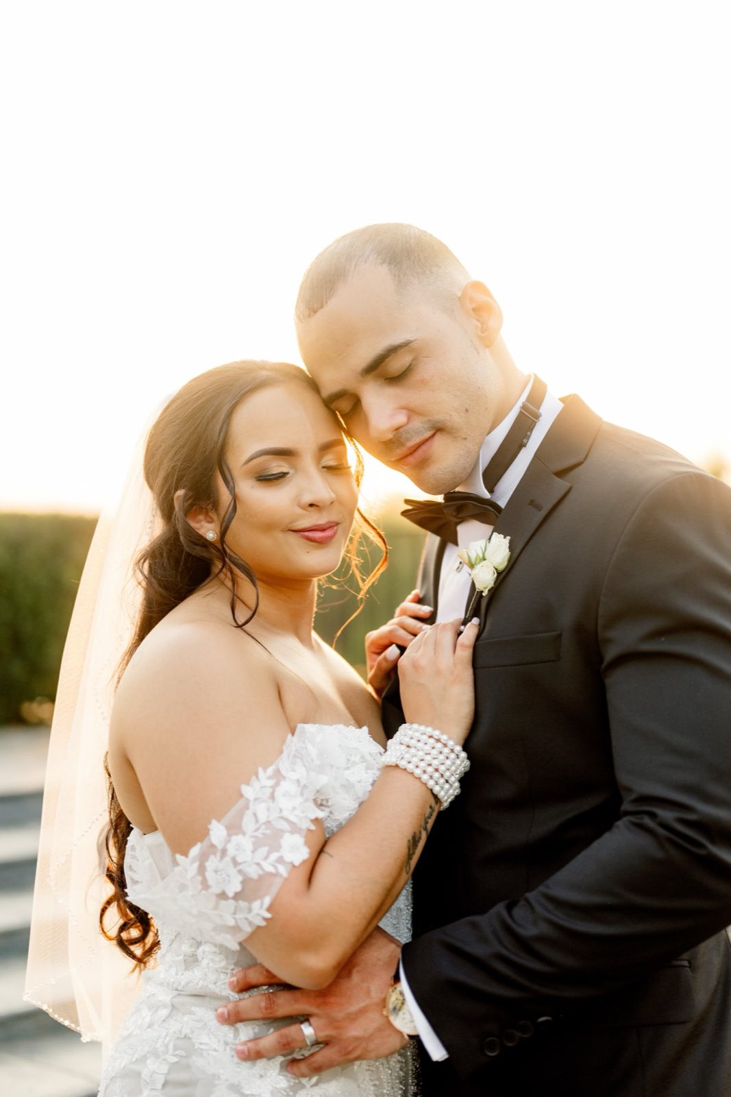 Newlyweds holding one another in golden light