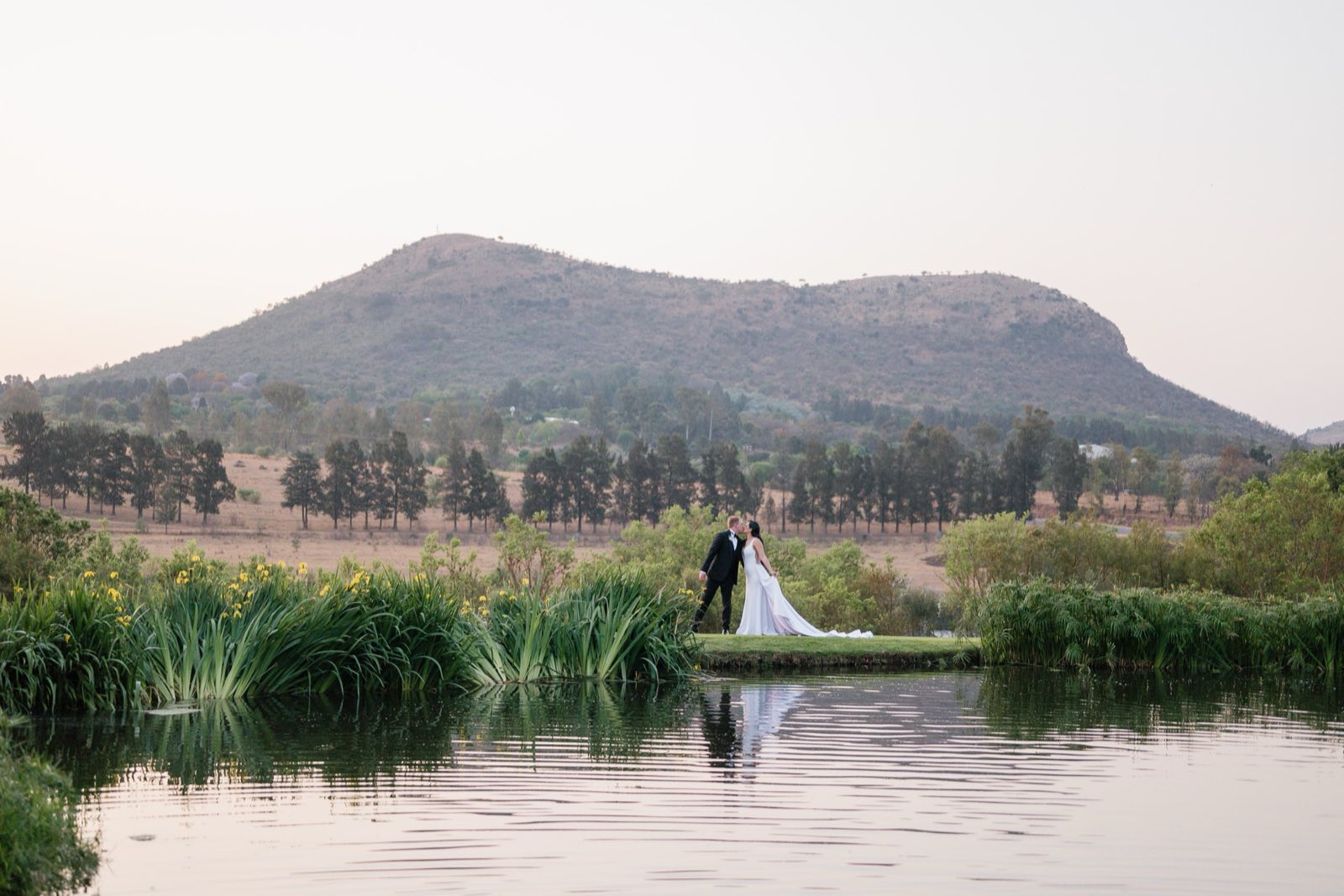 Newlyweds beside a mountain and a lake