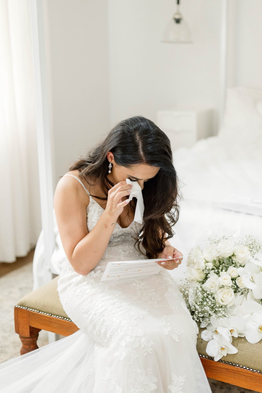 Bride reading a letter beside her flowers