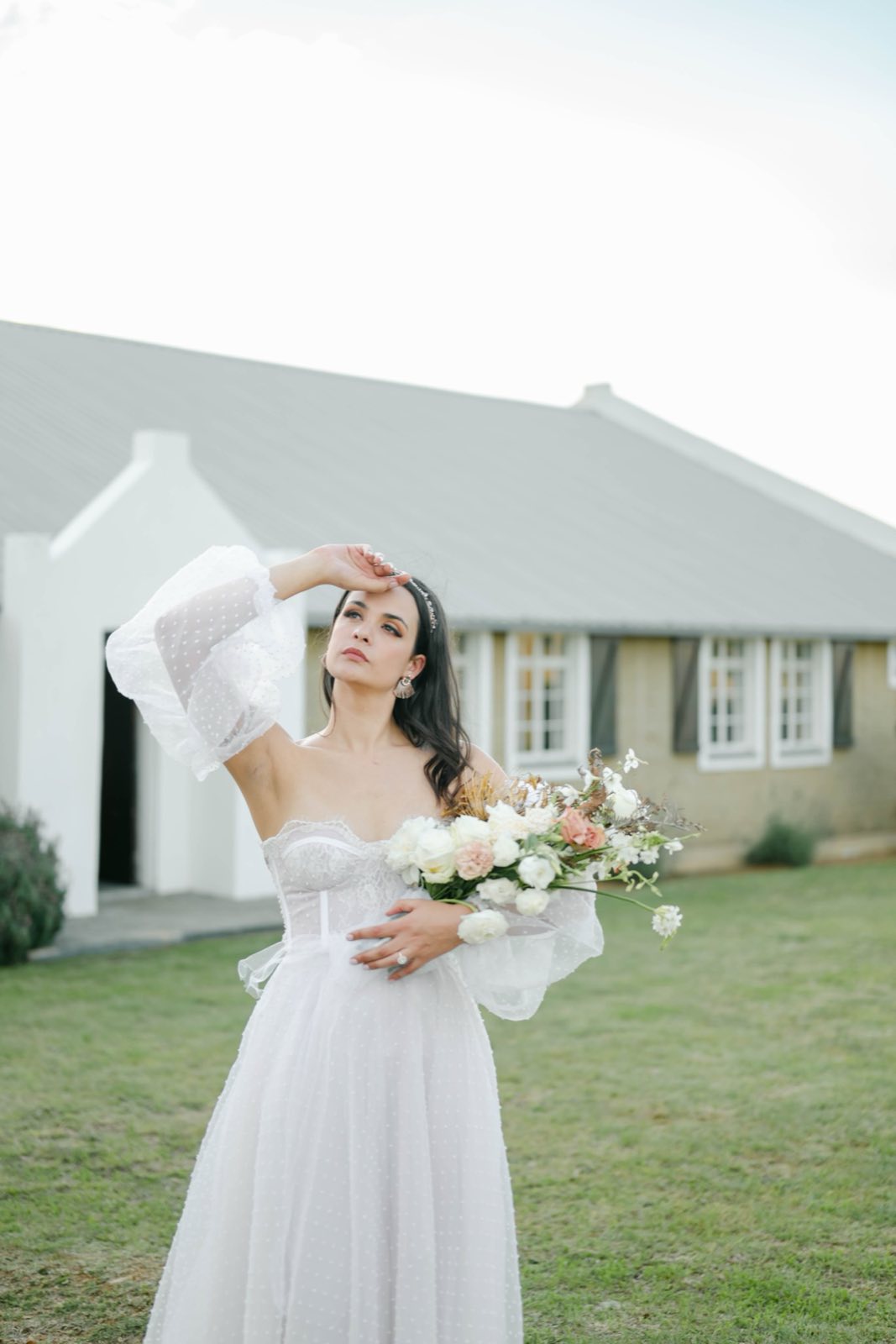 Bride with a bouquet outside a country house