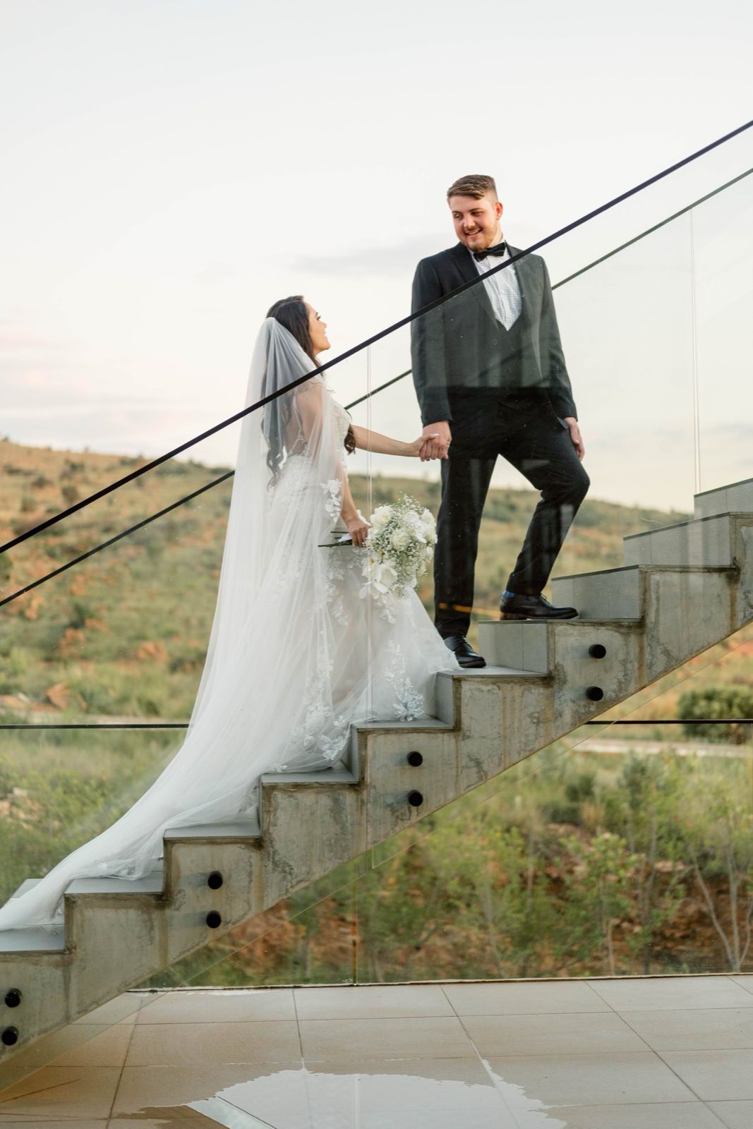 A couple walking up a glass staircase