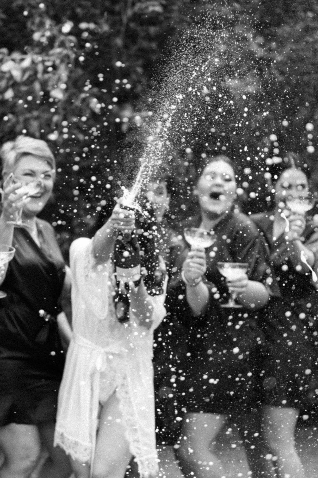 Friends celebrating with champagne in black and white