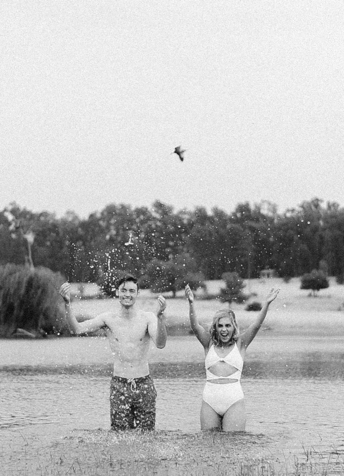 Couple celebrating together in a lake, photographed in black and white