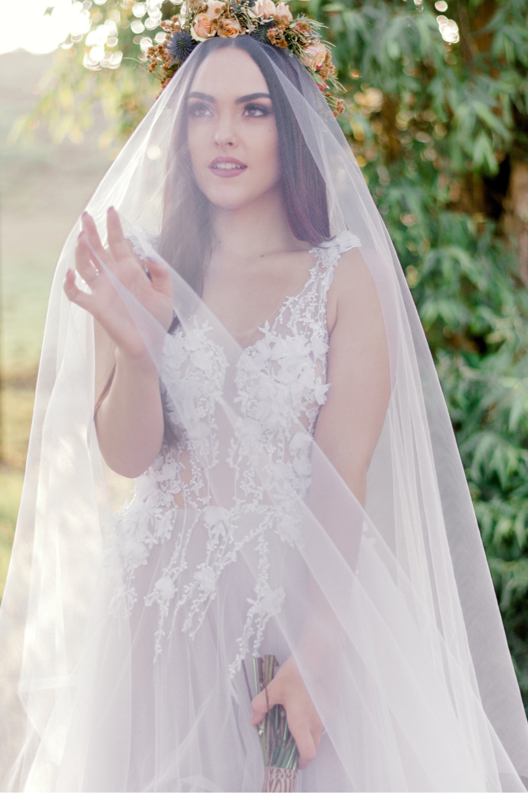 Bride beneath a floral crown and translucent veil