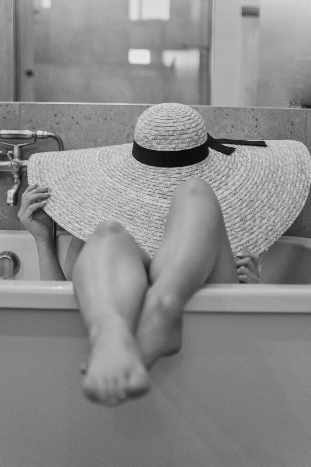 Playful black and white portrait with a wide-brimmed hat