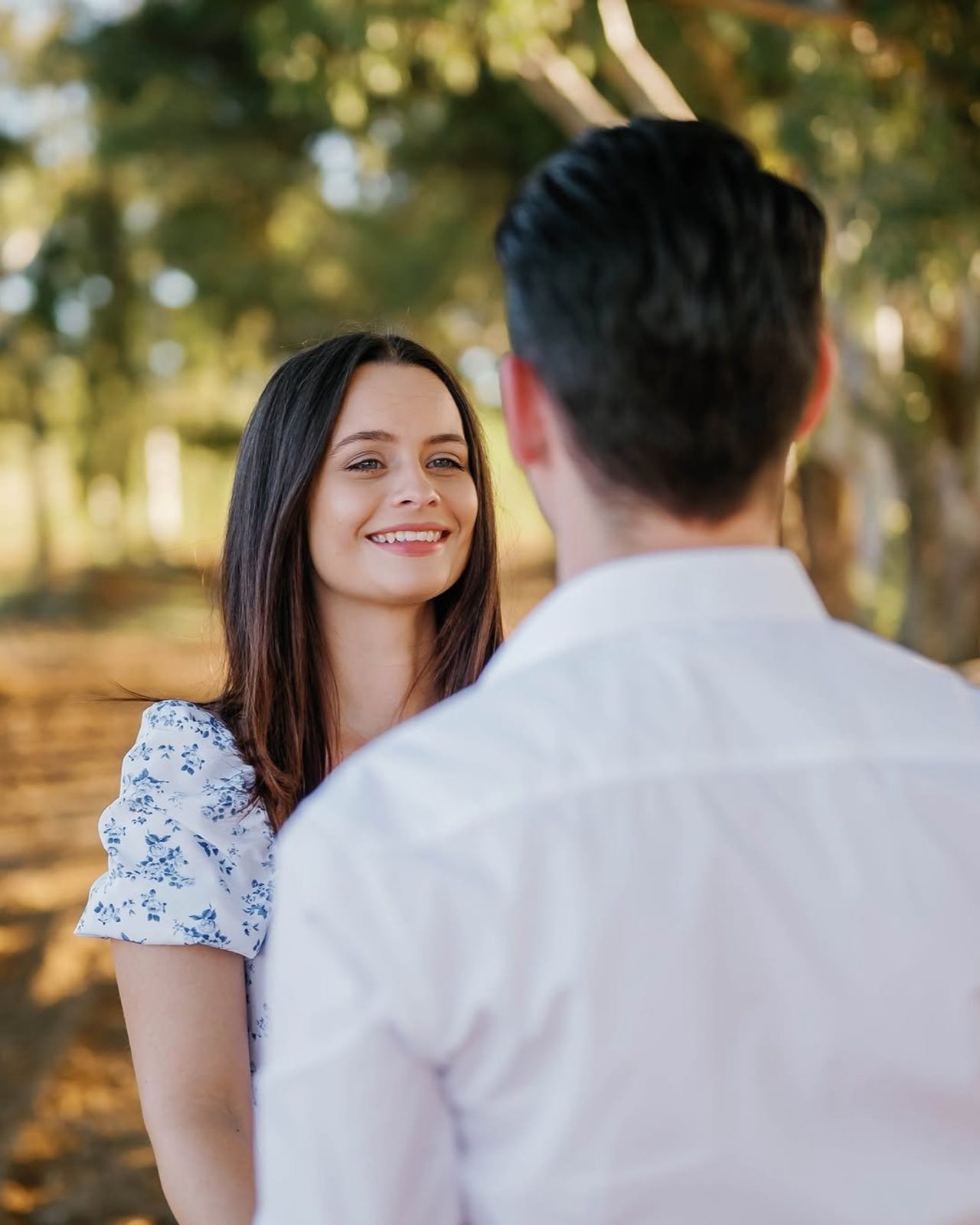 A couple smiling together in the woods
